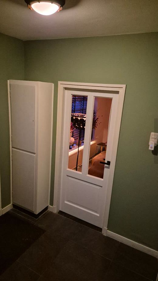 Afgehangen binnendeur met glas in een afgewerkte hal