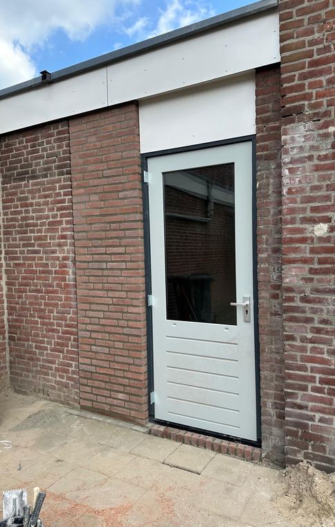 Nieuwe buitendeur met kozijn in een gemetselde gevel